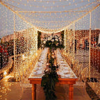 Table de fête décorée sous un rideau de guirlandes lumineuses