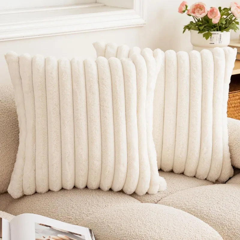 Housses de coussin en fausse fourrure ivoire à rayures sur un canapé